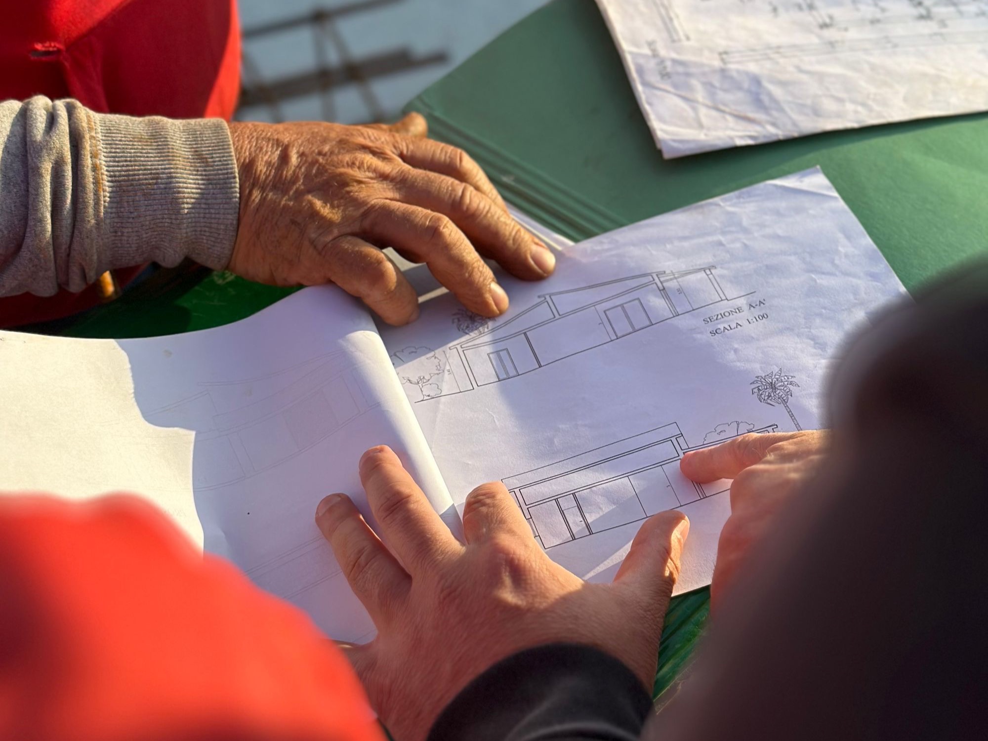 Ortstermin: Plan der Außenanlage wird auf dem Grundstück besprochen