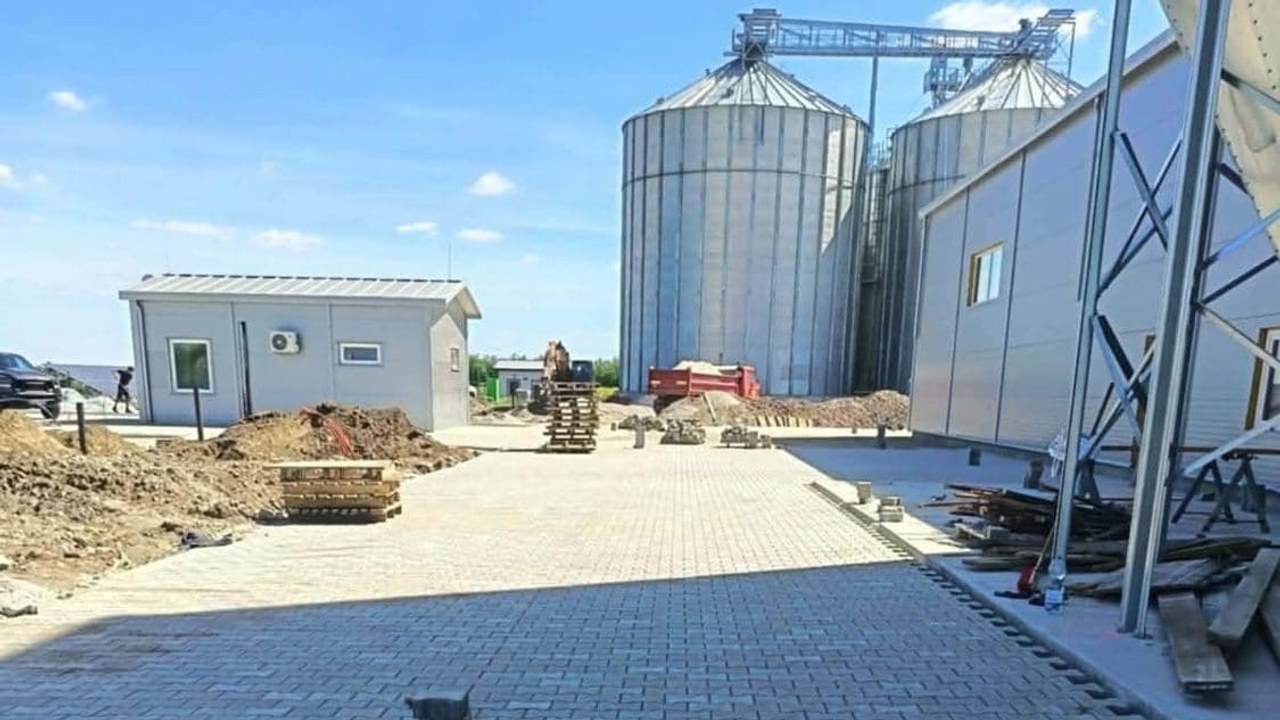 Neu gepflasterte Hoffläche eines Gewerbebetriebs mit Halle und Silos