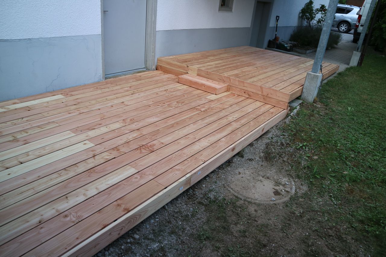 Neue Holzterrasse aus Lärche mit Stufe zum angrenzenden Bereich