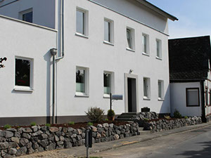 Nachher: neue Natursteinmauer entlang der Straße vor dem sanierten Wohnhaus
